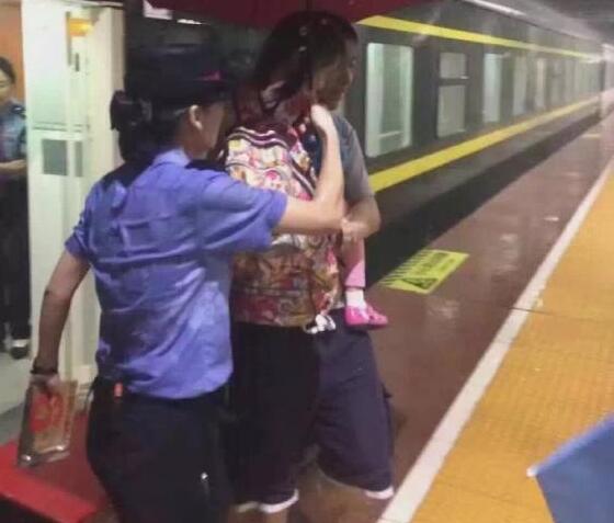 乘务员雨中撑伞护送旅客 浑身湿透