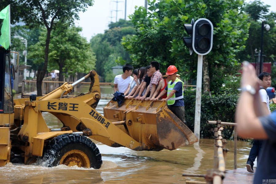 湖北武汉市区渍水 市民靠铲车出行