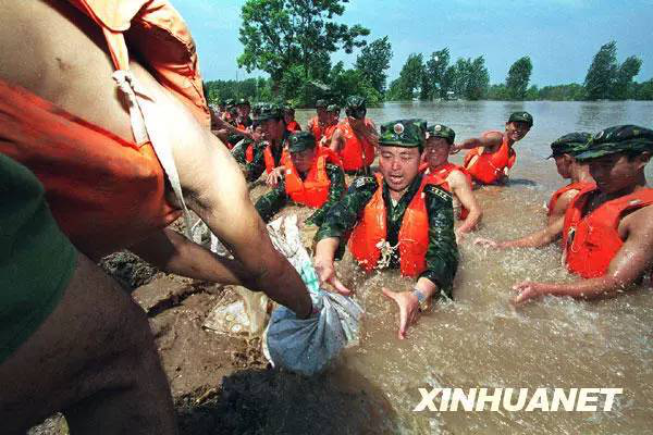 解放军济南军区某部官兵跳入洪水中在荆江大堤险段抢险（资料照片）。新华社发