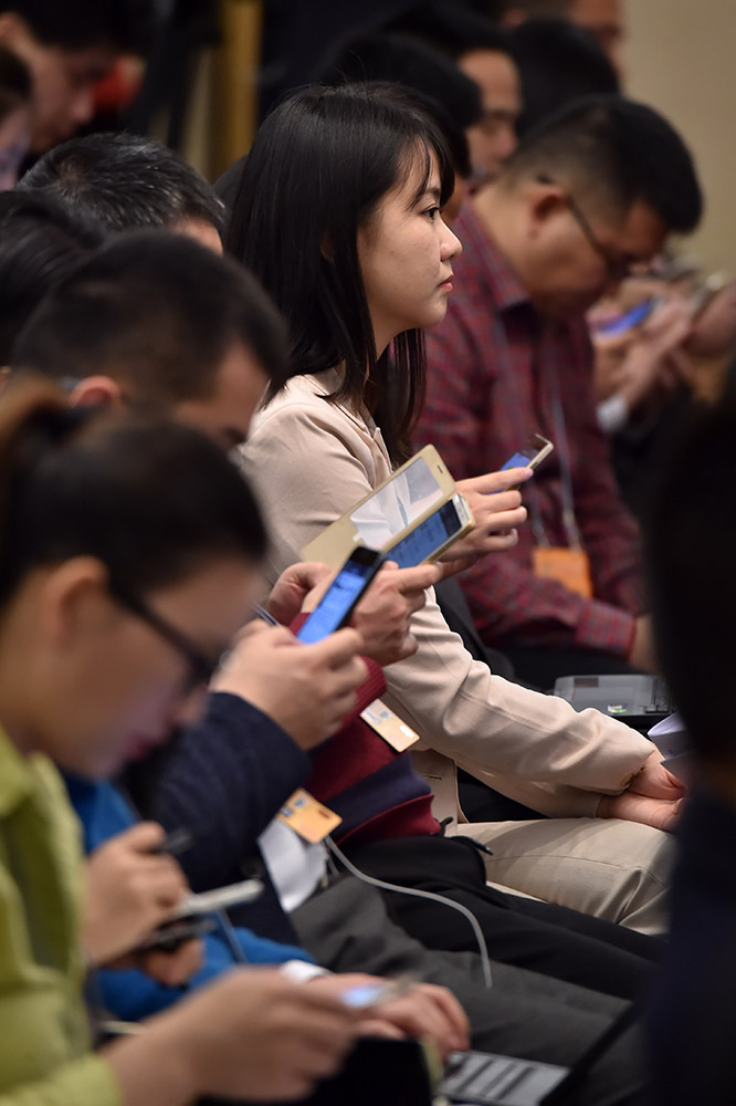 3月7日，在记者会上，认真听会的女记者。