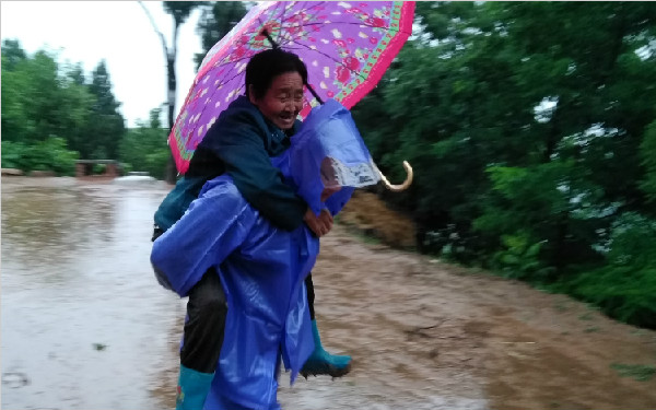 渭南遭遇强降雨老太不愿离开危房 镇干部背老太下山