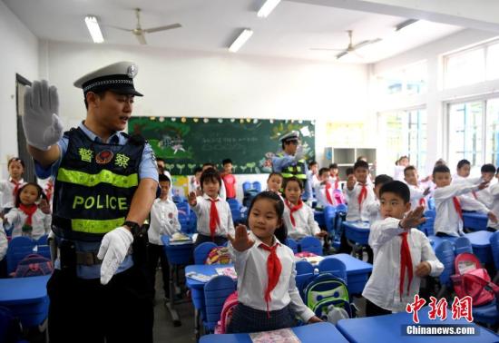 资料图：交警大队警官为学生讲解交通手势。<a target='_blank' href='http://www.chinanews.com/'>中新社</a>记者 韩苏原 摄