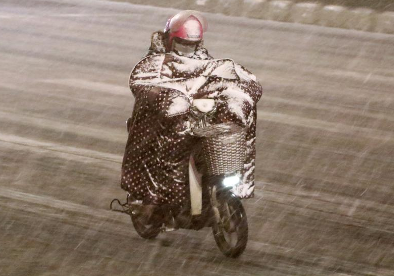 山东烟台遭遇强降雪 市民雪中出行一身白