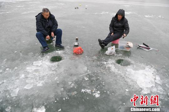 民众扎堆冰面垂钓取乐