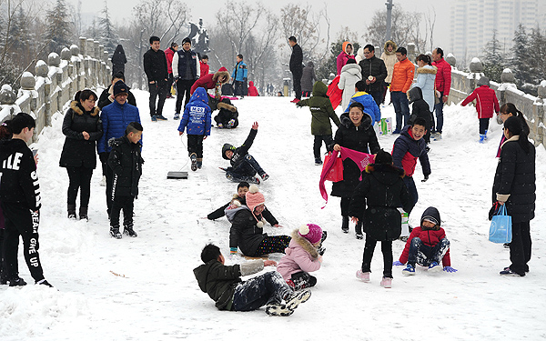 解锁新玩法！雪后公园拱桥变孩子的“滑雪场”