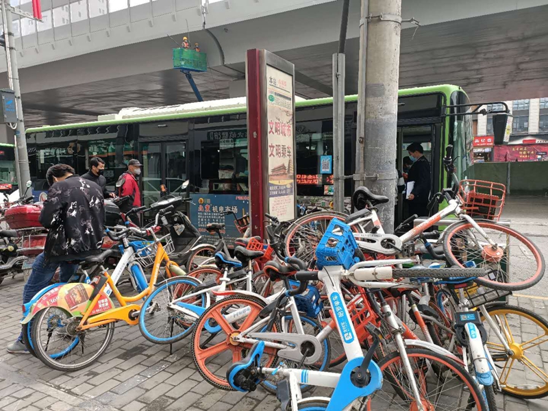 西桃园公交站附近共享单车胡乱堆放 公交站牌被“包围”