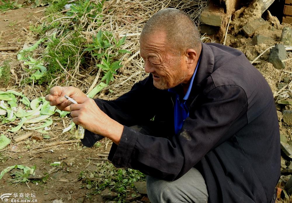 蹲在地头抽烟休息的老菜农