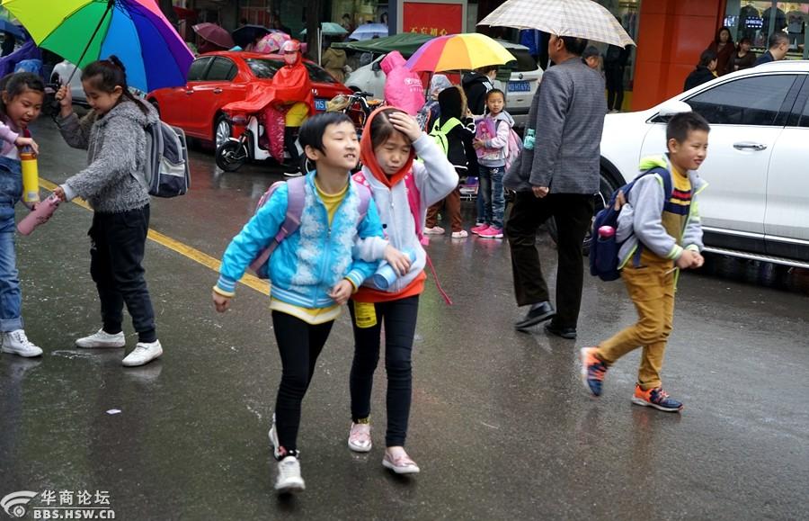 冒雨接放学孩子的家长们