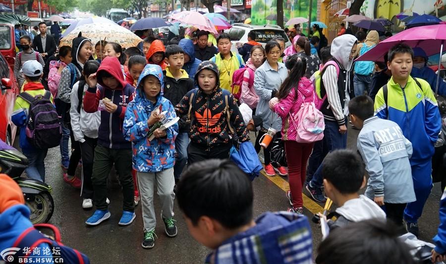 冒雨接放学孩子的家长们!