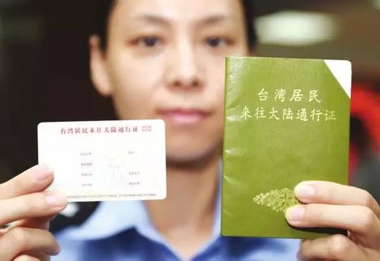 北京市公安局出入境管理总队的一名民警在展示电子台胞证样证（左）和本式台胞证的对比。新华社记者陈晔华 摄