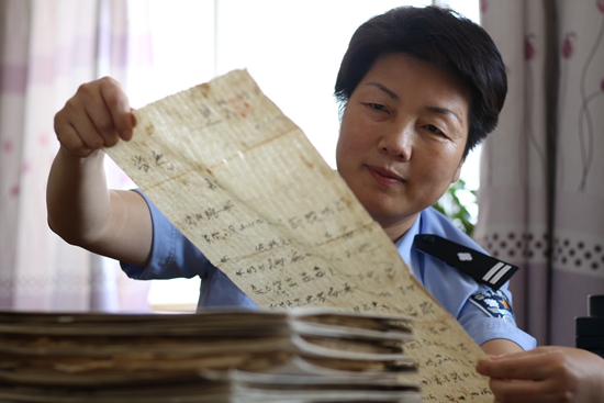 民警刘培英在布满灰尘和霉变暗黄的档案中搜集历史遗留物品.jpg