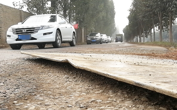 西安沣惠渠附近乡道铺路钢板一角翘起 过路车轮胎被划破
