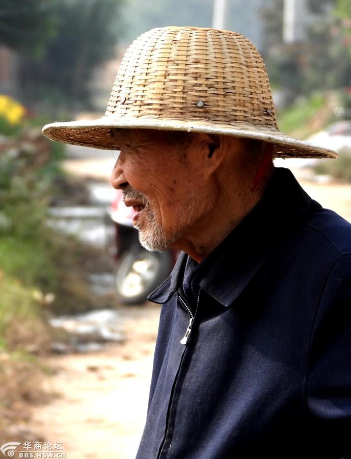为戴竹帽的八旬老农拍照留影
