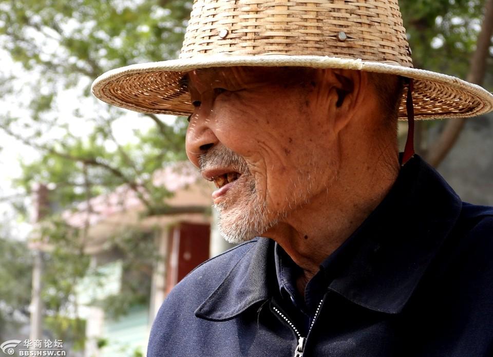 为戴竹帽的八旬老农拍照留影