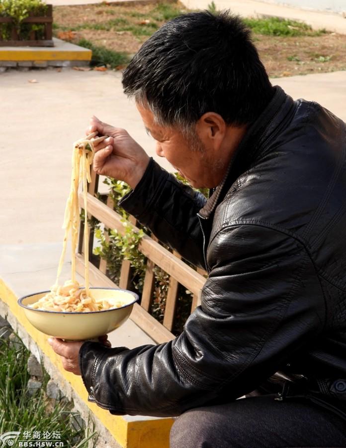 陕西关中农民喜欢蹲在家门口边吃面条边聊天