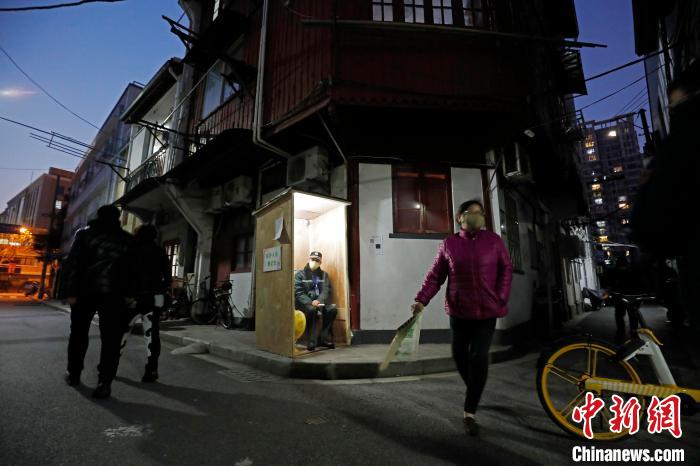 深夜里，保安人员在简易的保安亭内值守着。　殷立勤 摄